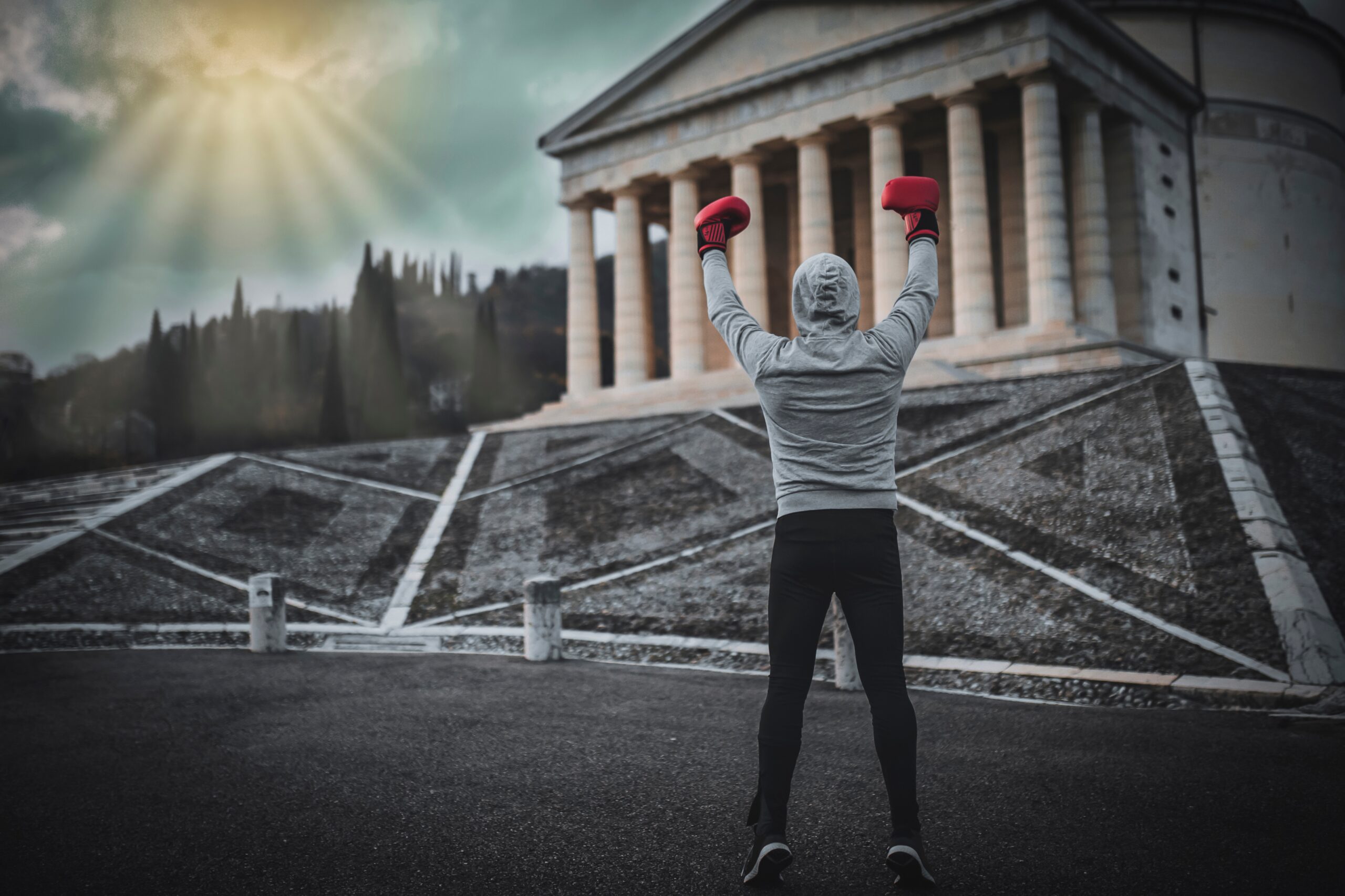 winning boxer with gloved hands raised standing in front of museum steps