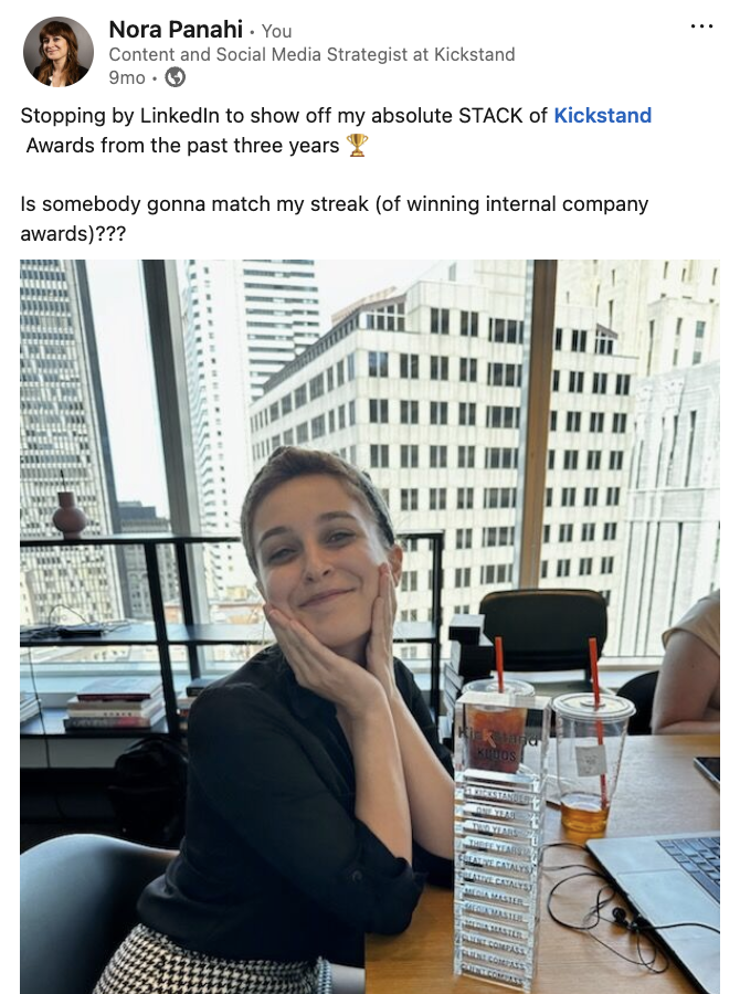 Candid photo of Nora from the Kickstand team, seated next to her award tower