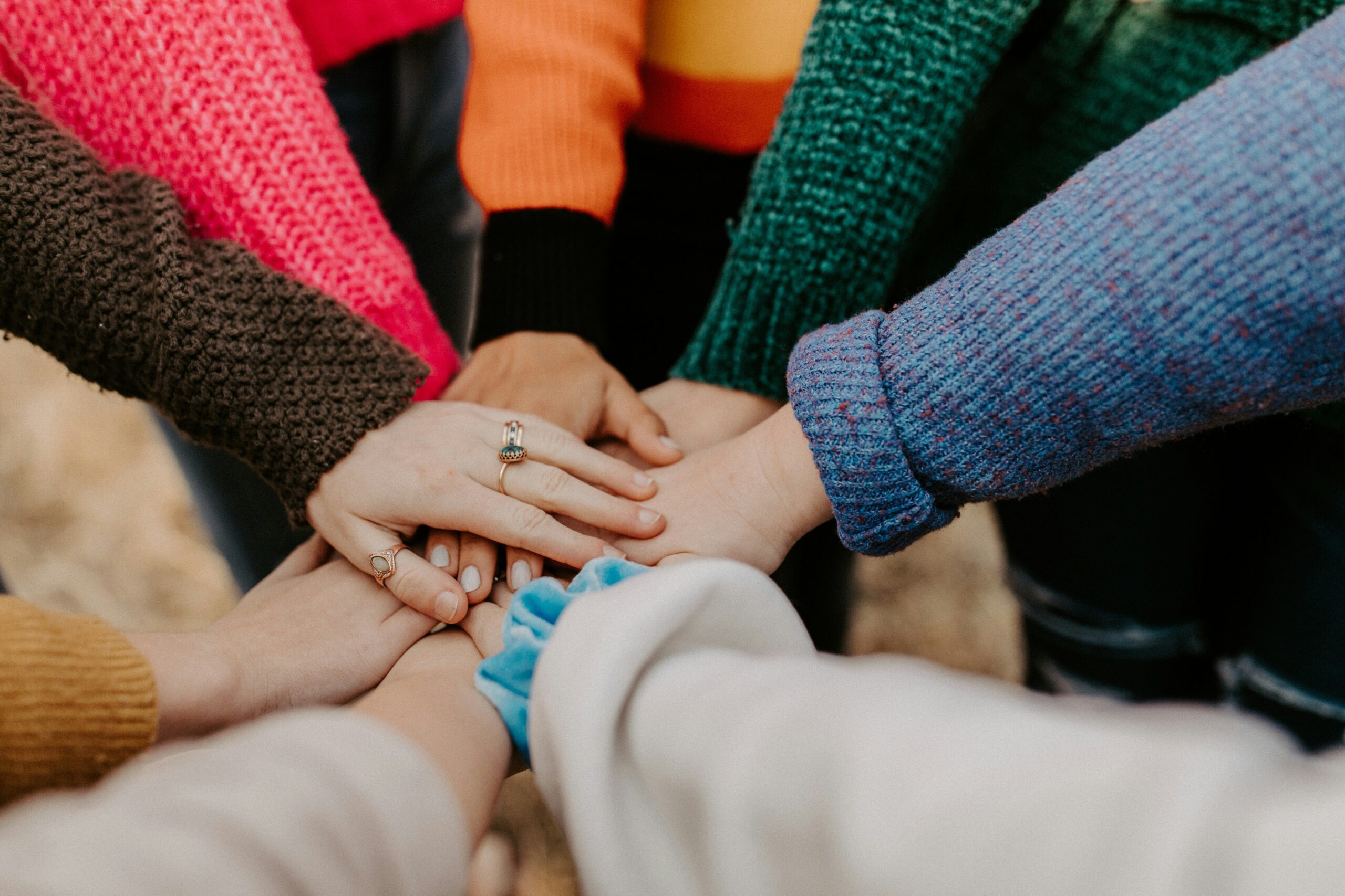 Photo of a team putting their hands in together ina team cheer