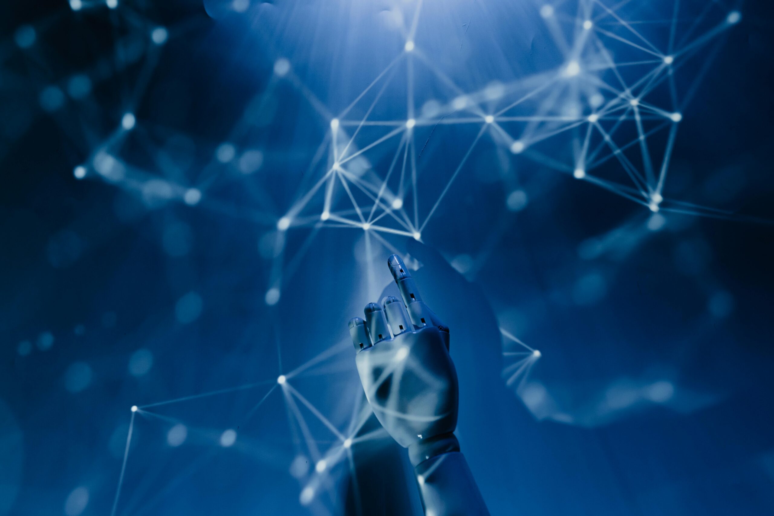 Stock photo of a robotic hand reaching into an abstract visualization of a network