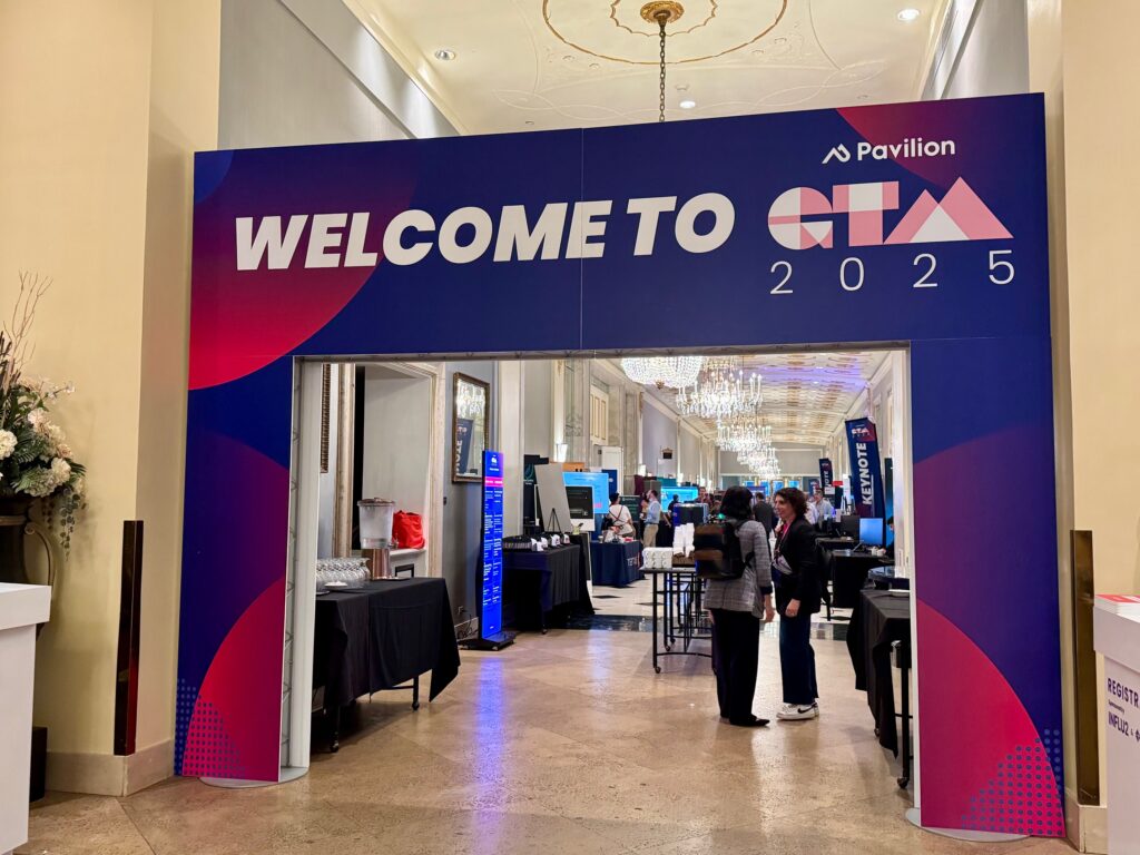 Photograph of the entry banner for the GTM conference, depicting the words "Welcome to GTM" against a purple and pink background 