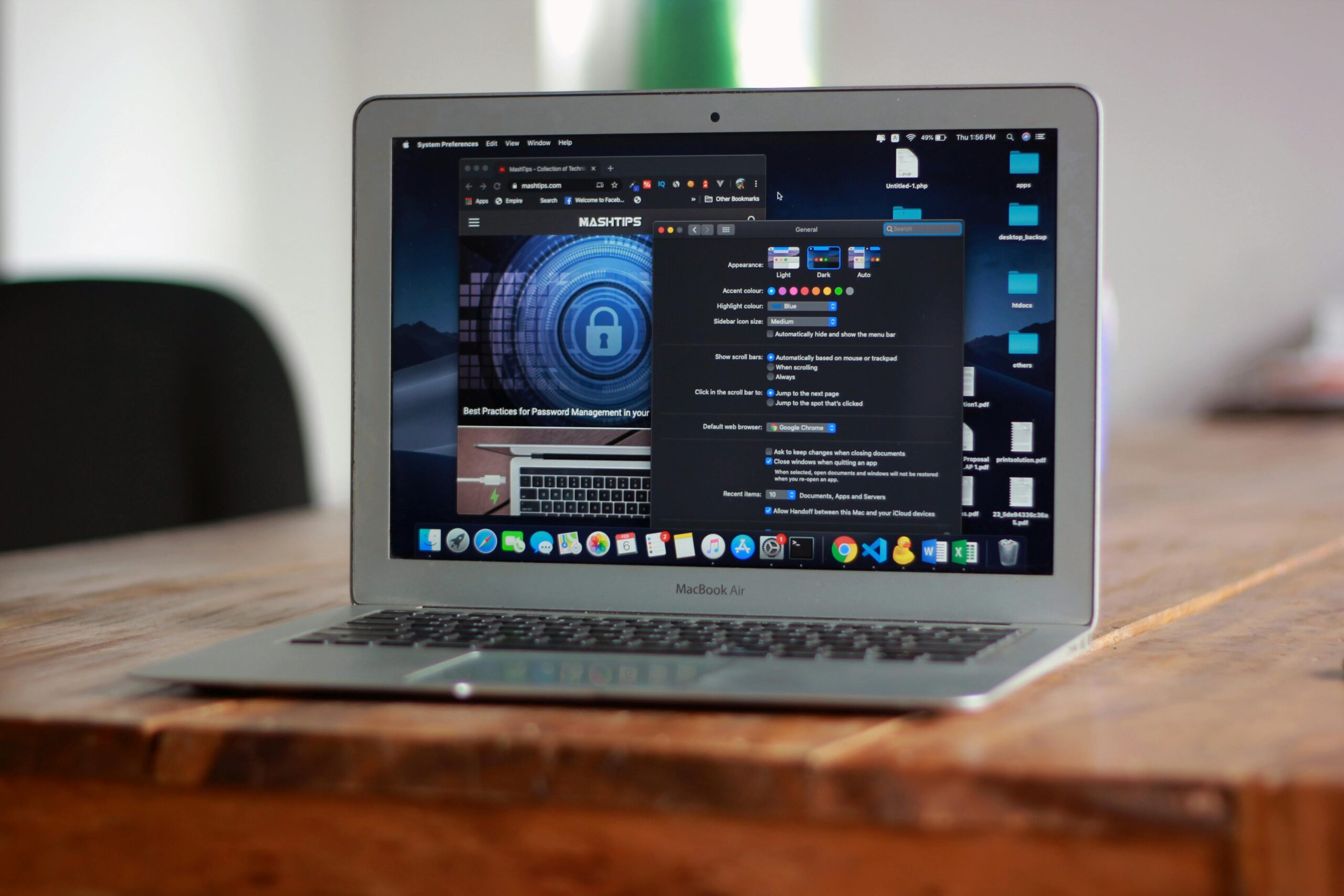 A laptop showing a black background dashboard sits on a wooden tabletop.