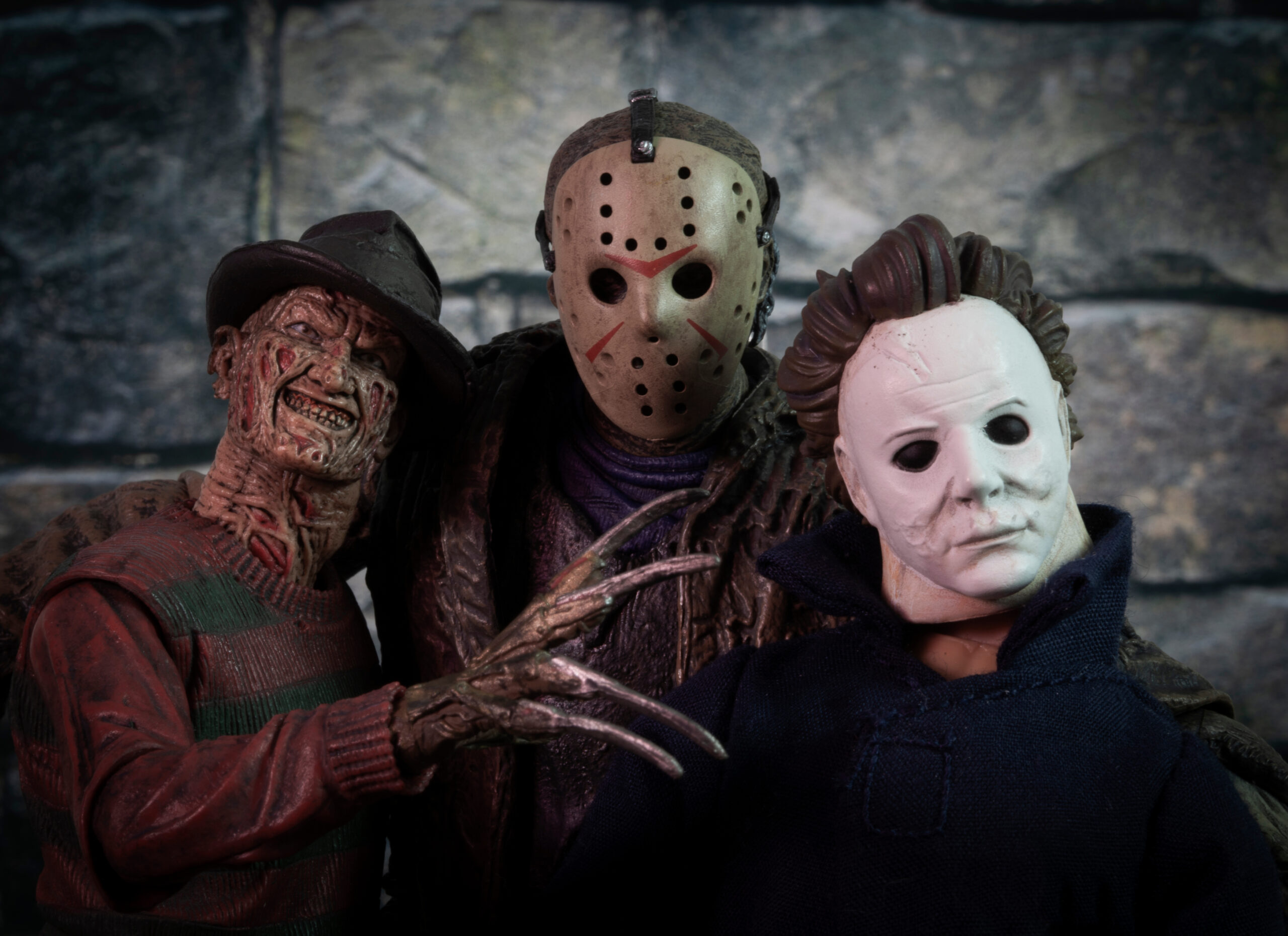 Stock photo of people dressed up in Halloween costumes as Freddy Krueger, Jason Voorhees, and Michael Myers from famous horror movie franchises